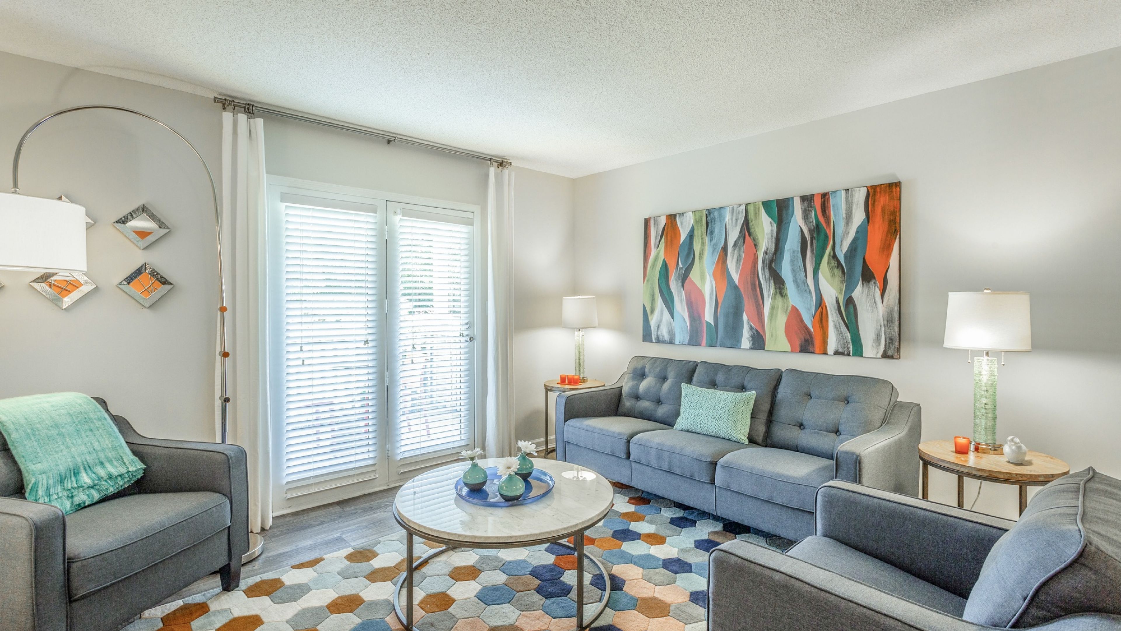 Hawthorne at Lily Flagg apartment living room with large patio doors, furnished with a couch, coffee table, and chairs
