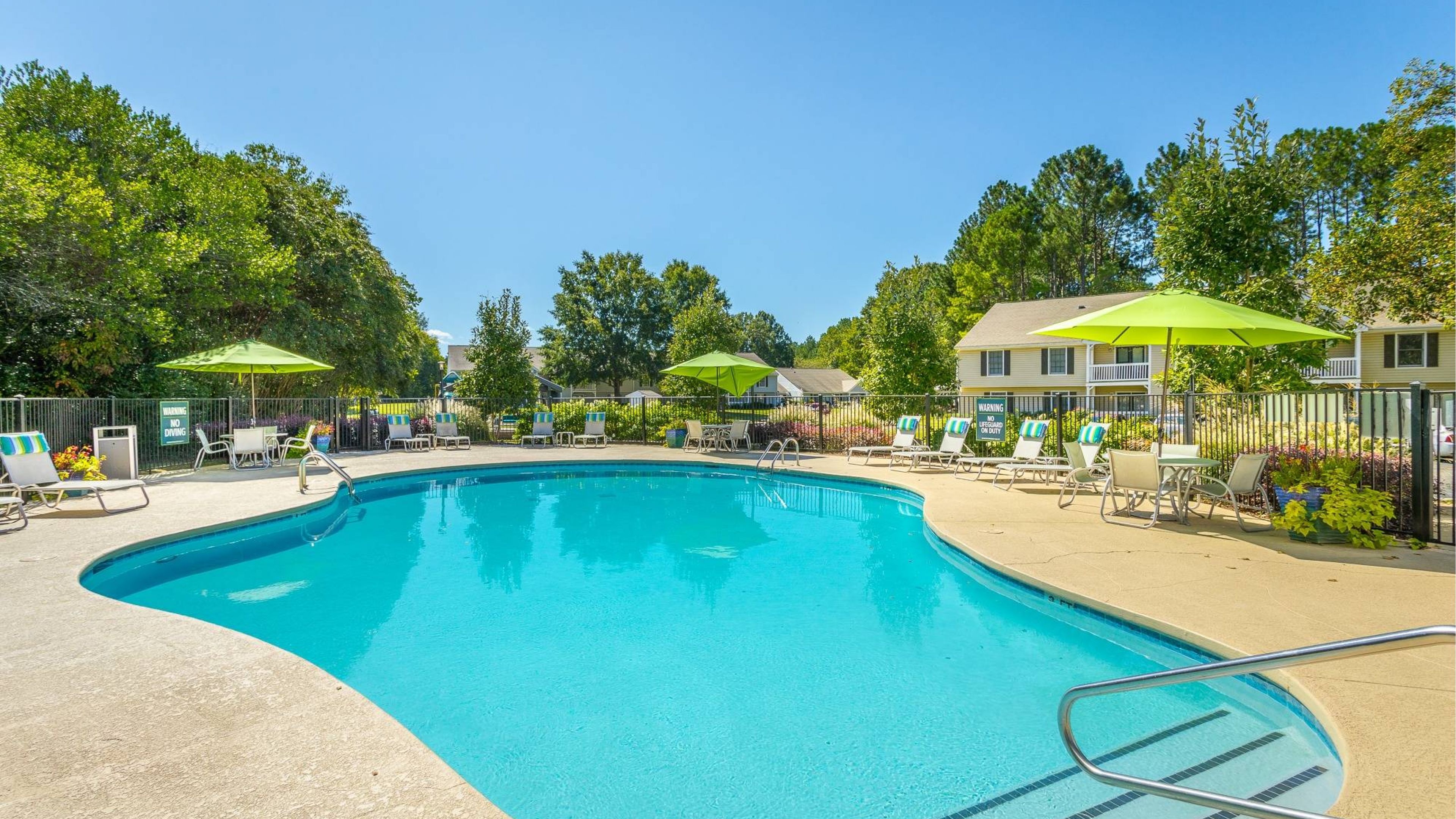 Hawthorne at Lily Flagg luxury outdoor pool with lounge chairs, umbrellas, and surrounding seating